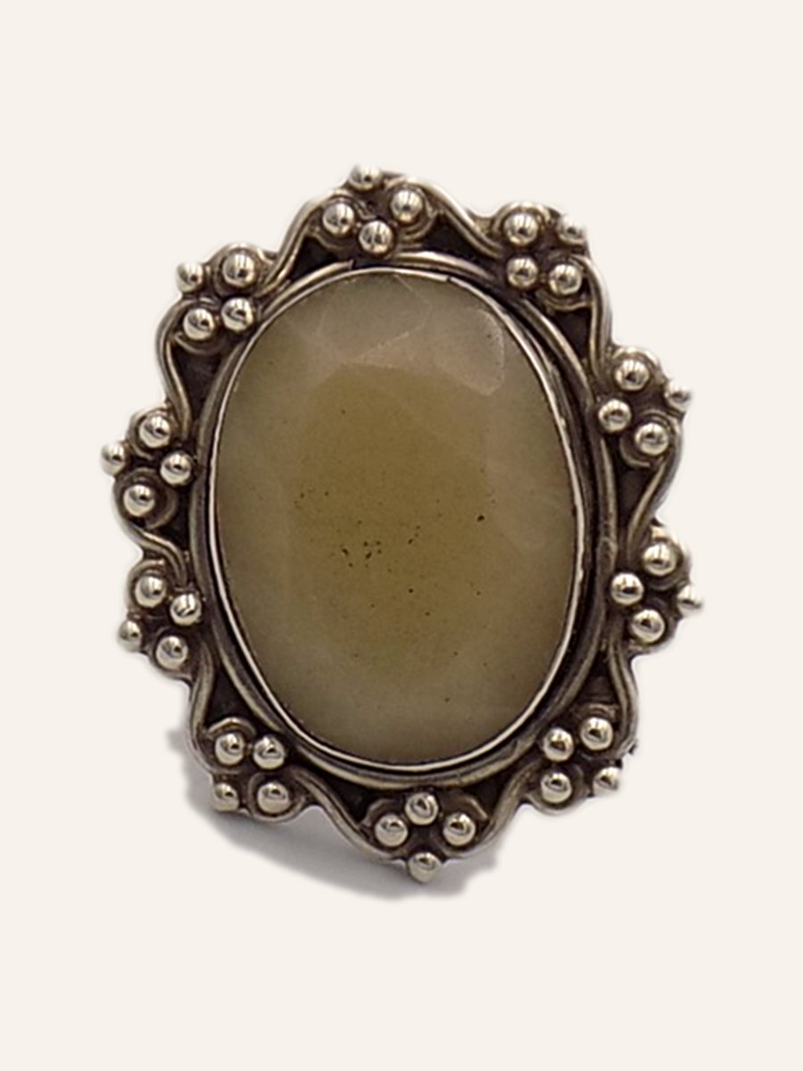 Ring with pale cabochon and beaded frame